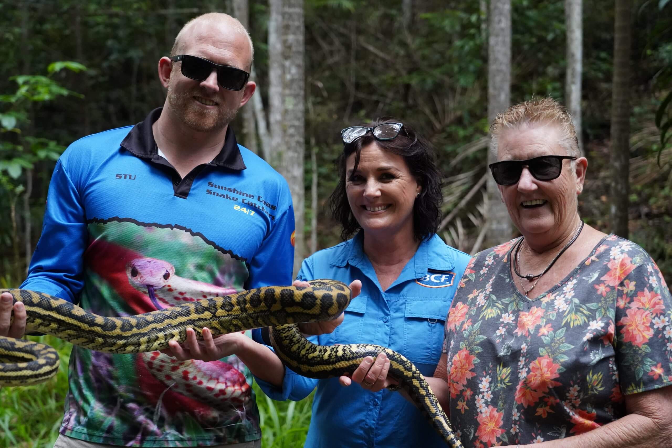 Stuart holding carpet python with two ladies