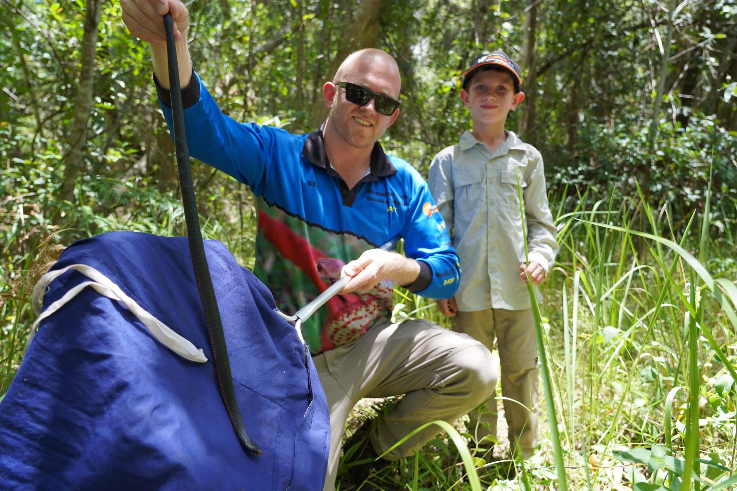 Young kid getting up close with snake catcher